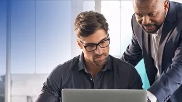 two men looking at a computer