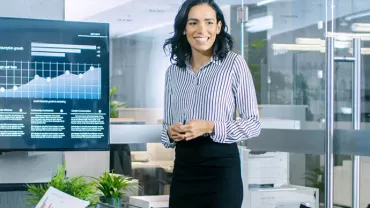 Person presenting data on a screen during a business meeting.