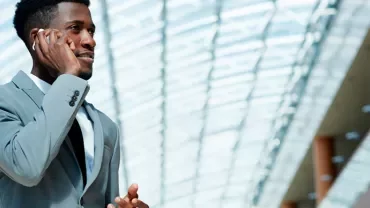 Person in a suit talking on the phone indoors.
