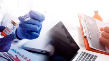 Healthcare worker prepares vaccine next to a clipboard.