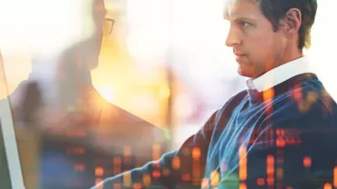 Person working at a computer with digital charts overlaid.