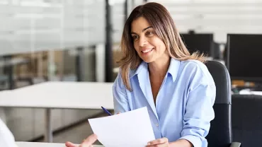 Person smiling during a meeting in an office setting.