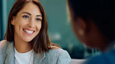 close up view of smiling professional woman over the shoulder of an interviewer