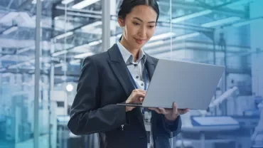 smiling woman in formal business wear holding laptop