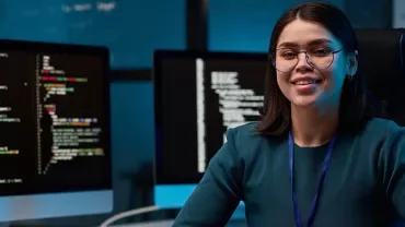 Individual looking happy with computers in the background