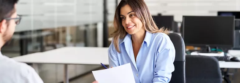 Person smiling during a meeting in an office setting.