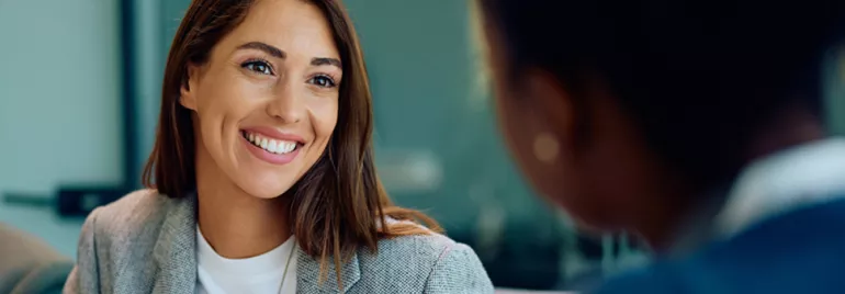 close up view of smiling professional woman over the shoulder of an interviewer